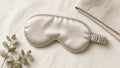 Champagne satin eye mask with ruched strap on cream linen